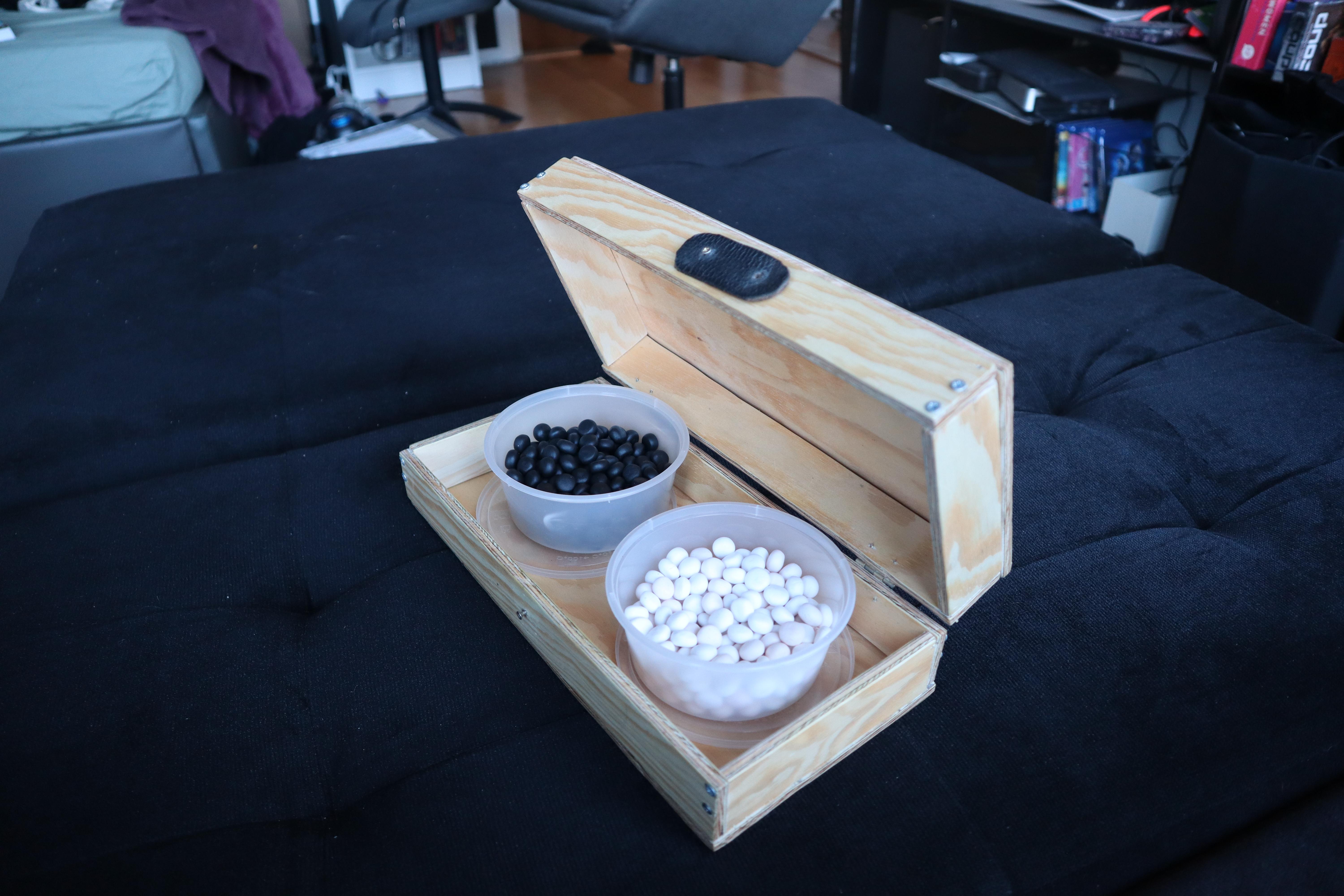 The same board half open showing how the pots of stones fit inside.