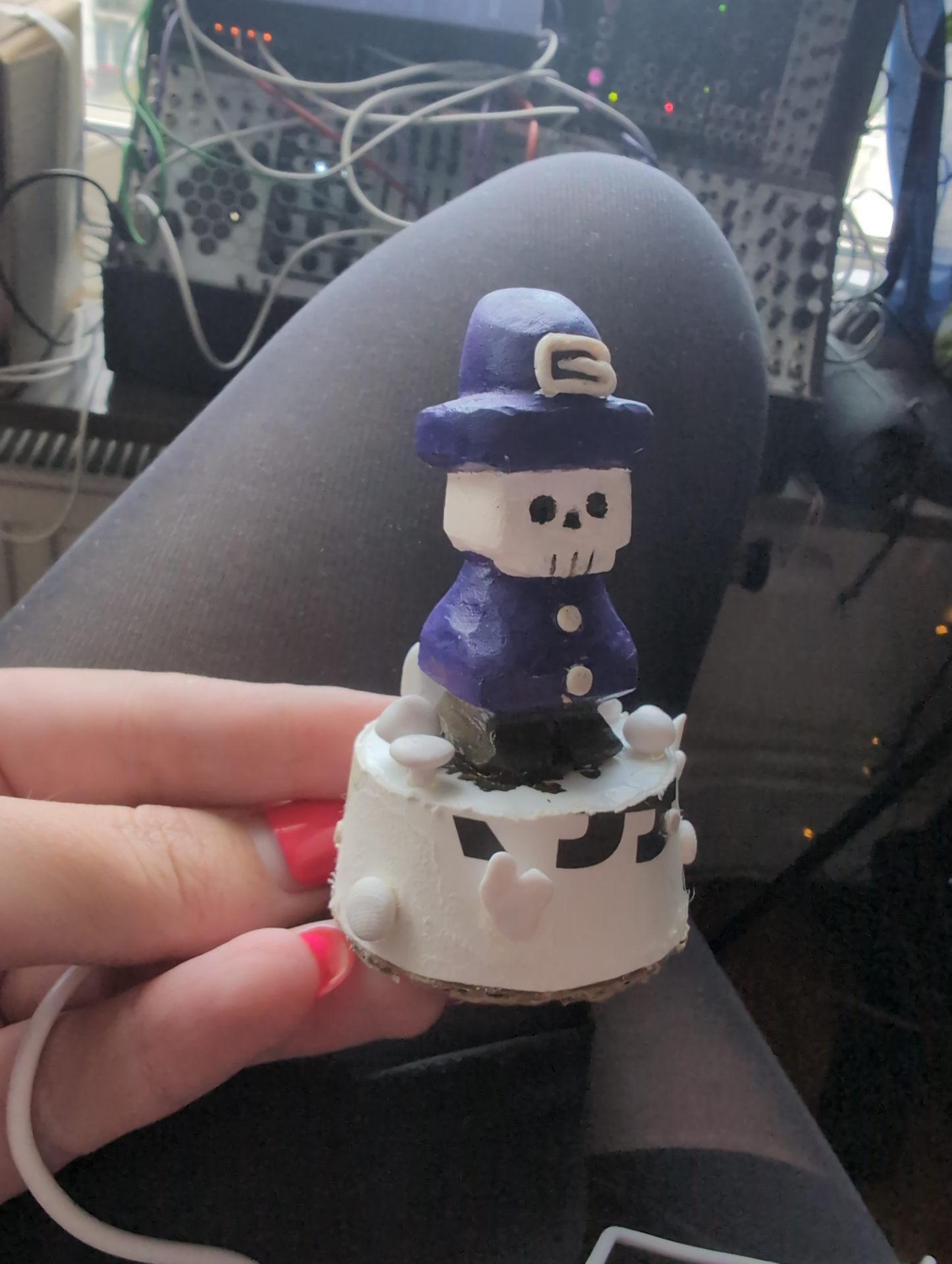 Little guy with polymer clay decorations modelled and attached with glue.