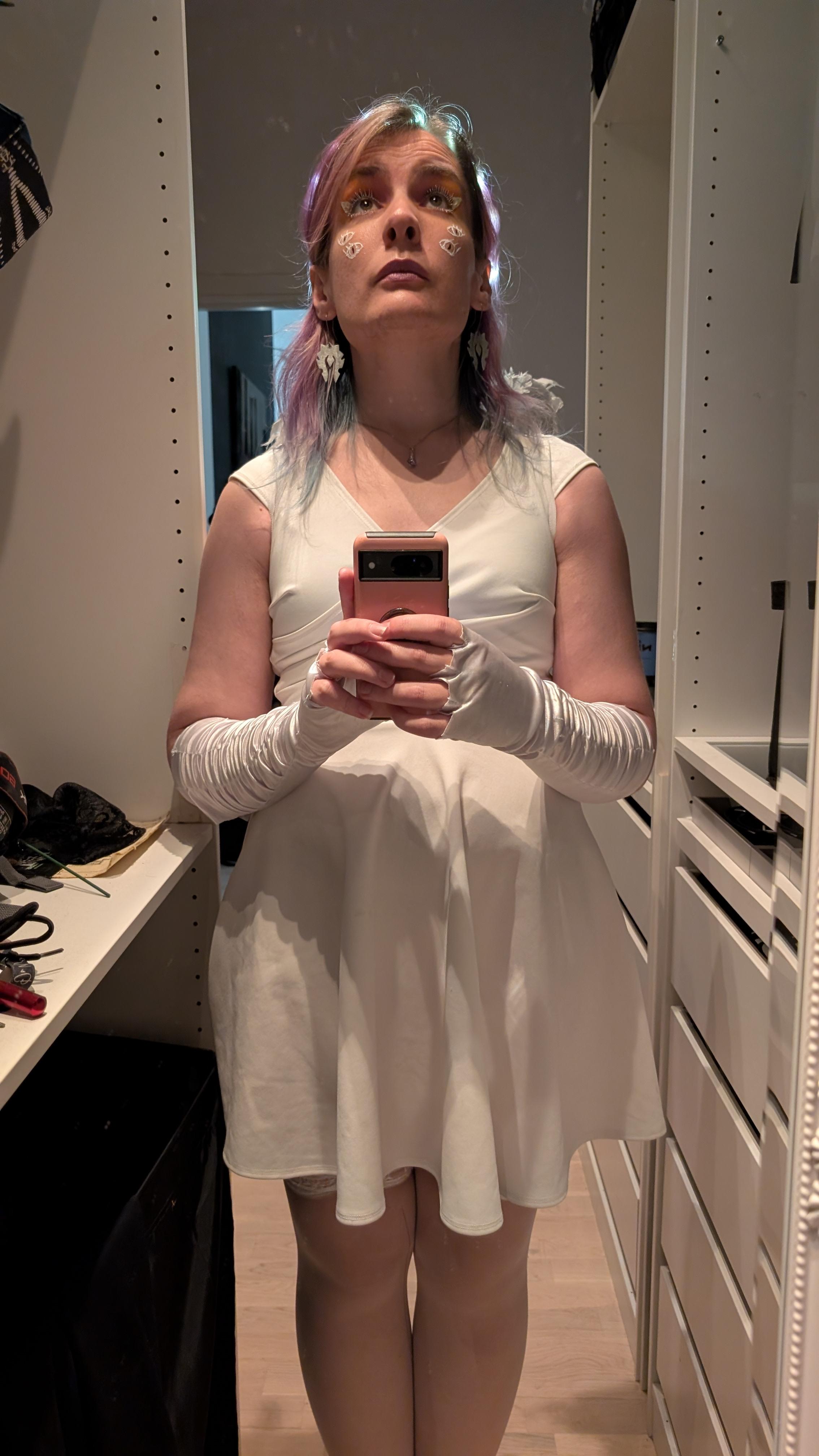 Ash in angel outfit looking up, lit from above, looking holy.