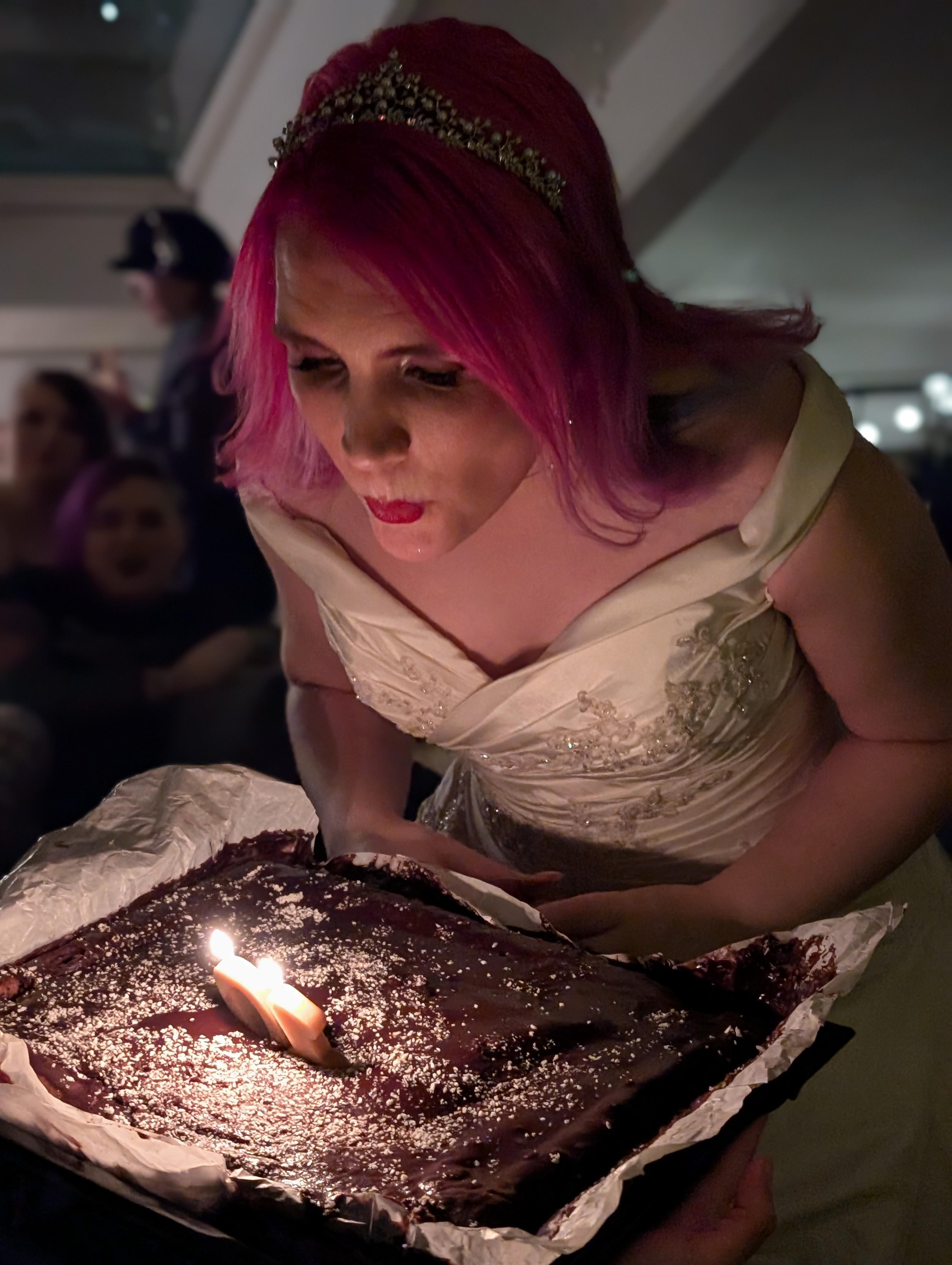 Ash blowing out "10" candles on a cake