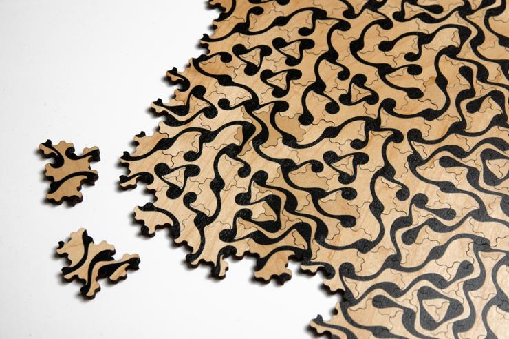 Wooden jigsaw puzzle of Spectre tiles with a black pattern printed on natural wood