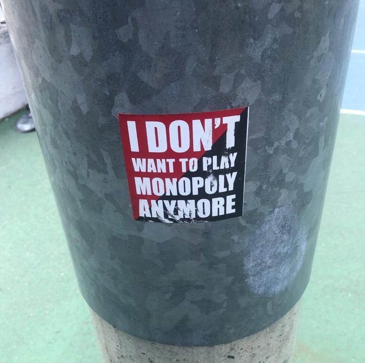 Sticker on a pole that says "I don't want to play Monopoly anymore"