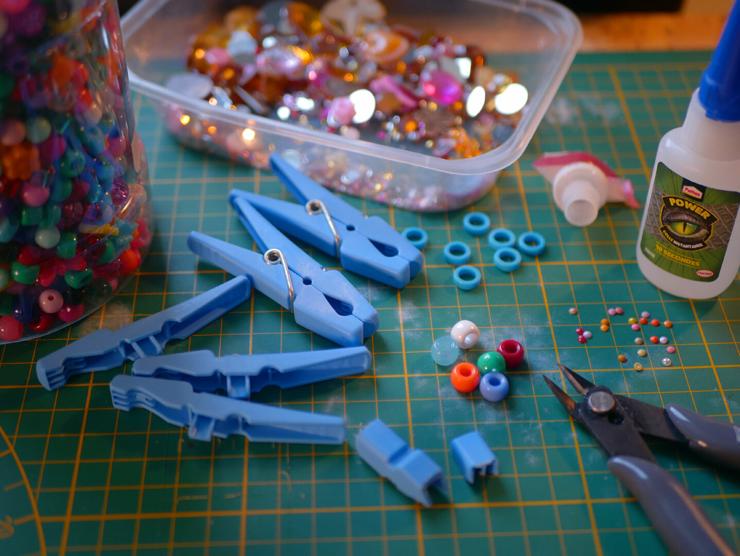 a work plan for model where we can see clothes pegs, beads, pliers and glue