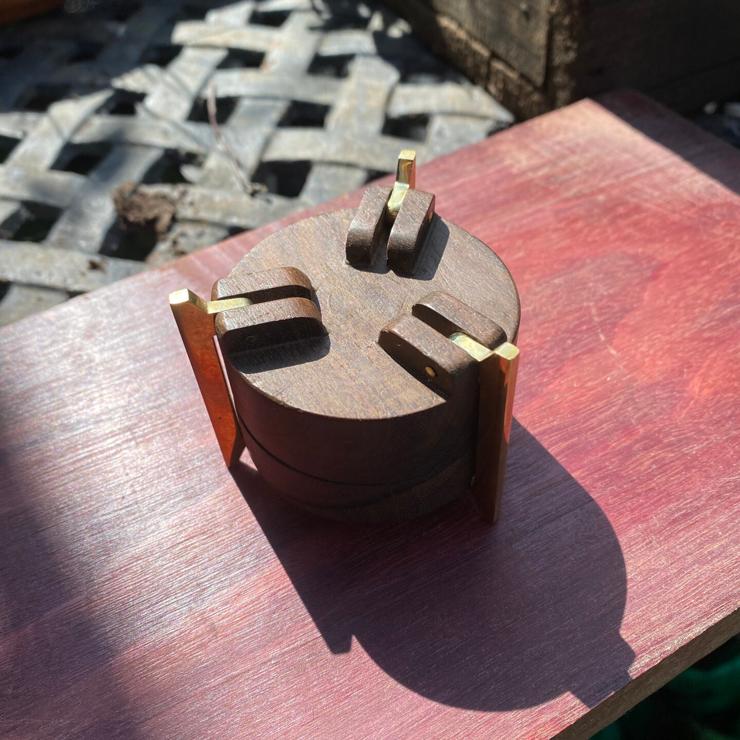 cylindrical ring box made of brass, zircote wood, with aquamarines on top. photo of underside